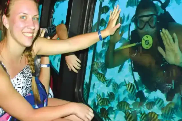 Manolo Tours tourists watching colorful fish through Sea Scope windows.