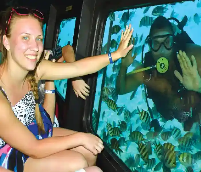 Manolo Tours tourists watching colorful fish through Sea Scope windows.