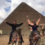 Tourists enjoying the pyramids panorama on Cairo day trip.
