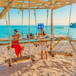 Manolo Tours tourists relaxing on bean bags at Paradise Island.