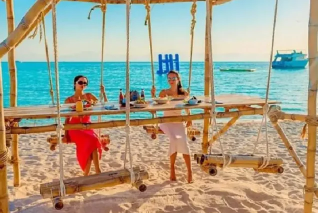Manolo Tours tourists relaxing on bean bags at Paradise Island.