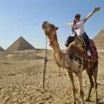 Camel riding at the Giza Pyramids during Cairo minibus trip.