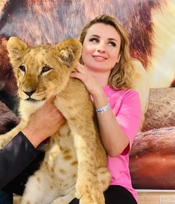 Woman holding a lion cub during baby lion Hurghada private safari tour